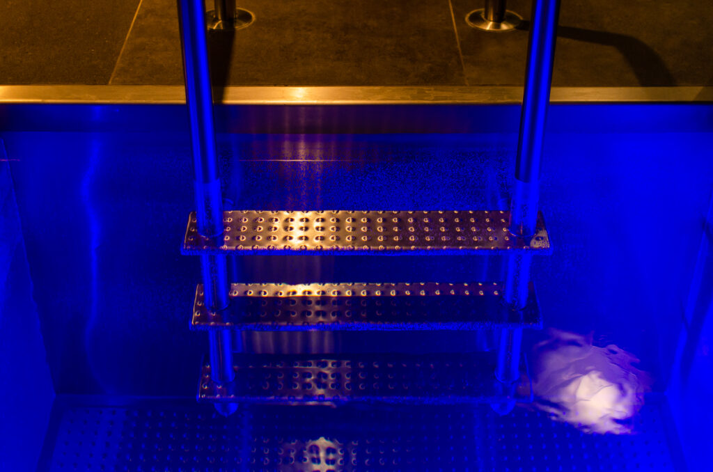 Detail of a stainless steel ladder in plunge pool IMAGINOX